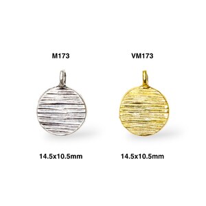 May include: Two round metal charms with a textured surface. The charm on the left is silver and the charm on the right is gold. Both charms are 14.5x10.5mm.