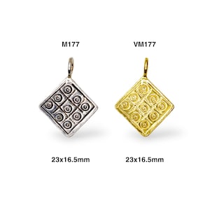 May include: Two silver and gold pendants with a geometric design. The pendants are shaped like a diamond and have a detailed pattern of circles and lines. The pendants are 23x16.5 mm in size. The silver pendant is labeled M1177 and the gold pendant is labeled VM1177.