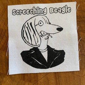 Puede incluir: Ilustración en blanco y negro de un beagle con traje y gafas de sol, con el texto "Screeching Beagle" arriba.