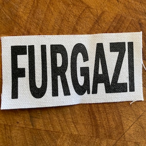 May include: White fabric patch with the word "FURGAZI" printed in black.