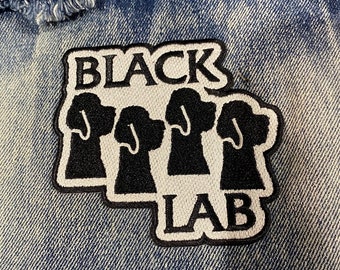 May include: Black and white embroidered patch with the text "BLACK LAB" and four black silhouettes of Labrador Retriever heads.