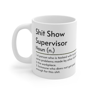 Puede incluir: Taza de cerámica blanca con el texto "Shit Show Supervisor Noun (n.)" y una definición. La definición describe a un supervisor como alguien que resuelve problemas y no está lo suficientemente bien pagado.
