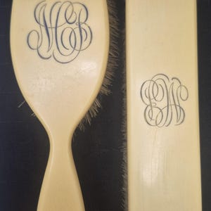 Pu&ograve; includere: Set spazzola e pettine per capelli color avorio. La spazzola ha un manico ed &egrave; di forma ovale, con un monogramma blu. Il pettine &egrave; rettangolare con un monogramma blu abbinato. Le setole sono marrone chiaro.