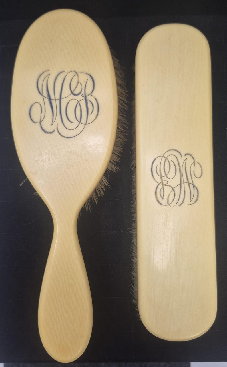 Pu&ograve; includere: Set spazzola e pettine per capelli color avorio. La spazzola ha un manico ed &egrave; di forma ovale, con un monogramma blu. Il pettine &egrave; rettangolare con un monogramma blu abbinato. Le setole sono marrone chiaro.