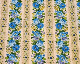May include: Fabric featuring vertical stripes with a repeating floral pattern of bright blue roses, small yellow blossoms, and green leaves. The background consists of alternating cream-colored bands and tan sections decorated with a delicate blue vine motif.
