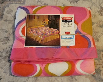 May include: A vintage Cannon Blanket, model A-9343, featuring a colorful Hour Glass design. The blanket is primarily pink, orange, and white with a retro pattern. It measures 72 x 90 inches. The original packaging is included.