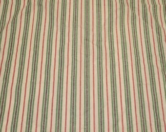 May include: A textile fabric featuring a repeating vertical striped pattern in shades of forest green, deep navy blue, and muted red against a cream-colored background. The material displays a consistent weave with visible linear texture throughout.