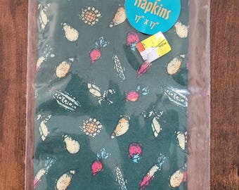 May include: A package of two Pocahontas-themed napkins, each 17" x 17", with a teal background and a pattern of various vegetables and flowers. The Disney's Pocahontas logo is visible at the top. The napkins are sealed in a clear plastic bag.