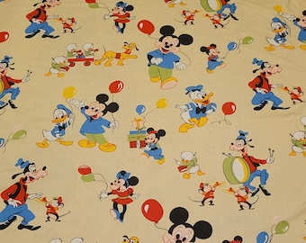 May include: A light beige fabric featuring a repeating pattern of classic Disney characters including Mickey Mouse, Minnie Mouse, Donald Duck, Goofy, and Pluto. The characters are depicted in colorful outfits, holding balloons, playing drums, and carrying gifts.