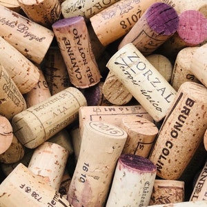 May include: A close-up of a pile of wine corks with various labels and text, including "Zorzal Terrois unico", "Cantina Del Notato", "Bruno Colin", and "Chateau".
