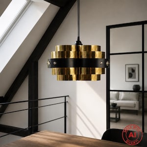 May include: A pendant light fixture featuring a series of stacked, polished gold-tone metal rings arranged in a tiered cylindrical shape, secured by a central matte black horizontal band with visible metallic rivets, suspended by a black cord.