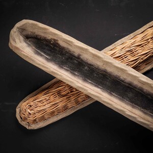 Könnte beinhalten: Zwei geflochtene Körbe aus natürlichen Materialien. Ein Korb ist braun und hat ein schwarzes Innenleben. Der andere Korb ist aus geflochtenem Weidengeflecht.