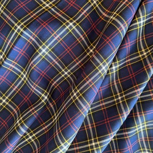 May include: Blue, red, white, and yellow plaid fabric with a woven texture.