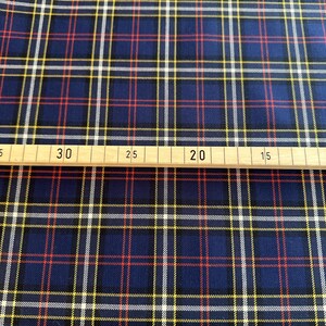 May include: Blue, red, white, and yellow plaid fabric. The fabric is measured with a ruler showing 30 inches.