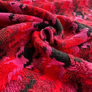 Puede incluir: Tela de pata de gallo roja, rosa y negra con un patr&oacute;n tejido texturizado.