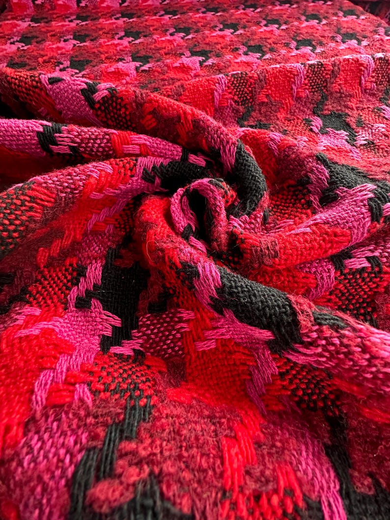 Puede incluir: Tela de pata de gallo roja, rosa y negra con un patr&oacute;n tejido texturizado.