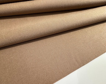 Könnte beinhalten: Nahaufnahme eines braunen Stoffes mit subtiler Textur. Der Stoff ist an mehreren Stellen gefaltet und zeigt den Fall und den Fluss des Materials.