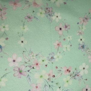 May include: A light green fabric with a delicate floral pattern. The flowers are pink, white, and blue, and they are scattered randomly across the fabric.