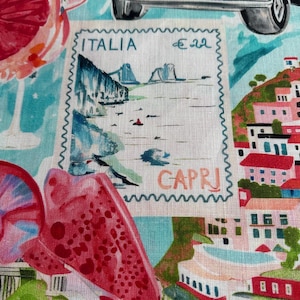 Könnte beinhalten: Ein Stoffdruck mit einer Briefmarkenillustration mit der Aufschrift ITALIA und CAPRI, die eine Küstenlandschaft zeigt. Das Design umfasst ein rosa Oldtimer-Auto, rote Zitrusfrüchte und bunte Gebäude auf einem hellblauen Hintergrund.