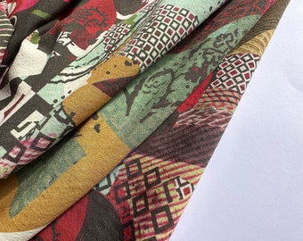 May include: A colorful fabric with a geometric pattern featuring squares, rectangles, and abstract shapes in shades of red, brown, yellow, and green.