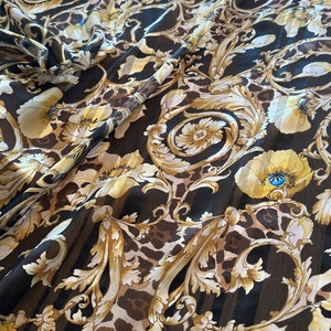 Könnte beinhalten: Schwarzer, durchsichtiger Stoff mit einem goldenen und braunen Barockdruck mit floralen und Leopardenmustern.
