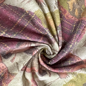 May include: Close-up of a patterned fabric with a swirling design. The fabric features a mix of colors, including burgundy, olive green, and beige. The pattern includes plaid and floral elements, creating a textured and detailed appearance. The fabric appears soft and possibly woven.