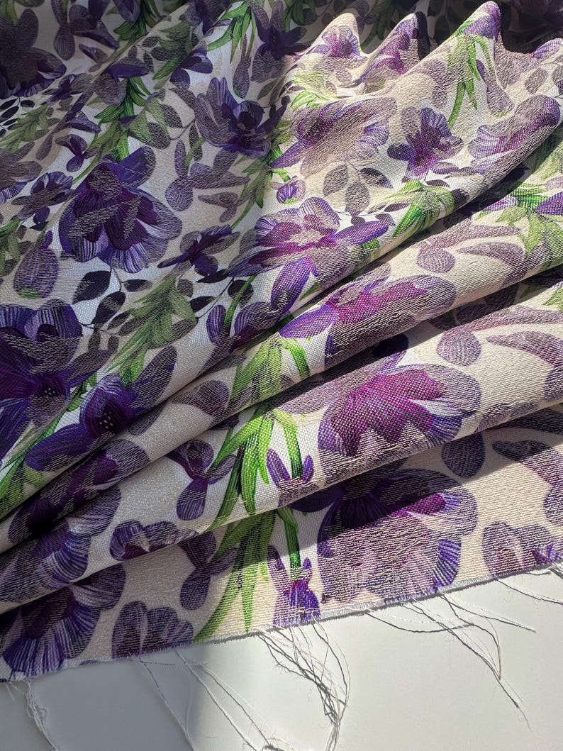 May include: Purple floral fabric with a white background. The fabric has a textured surface and a subtle sheen.