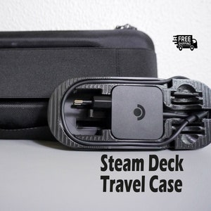 May include: A black travel case with a moulded interior designed to hold a Steam Deck handheld gaming console and accessories. The case has a zipper closure and a handle.