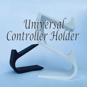 May include: A white and black 3D printed universal controller holder. The holder is shaped like a letter S and has a curved base. The text "Universal Controller Holder" is written in black cursive above the holder.