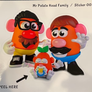 May include: A sticker featuring a Mr. Potato Head family. The father has black hair, glasses, and a mustache. The mother has brown hair and a mustache. The baby has a green leaf on its head and a pacifier. The sticker says "Mr. Potato Head Family / Sticker 0017" and "Peel Here".