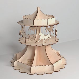 Può includere: Un espositore in legno a tema giostra con più livelli. La giostra presenta figure di cavalli ritagliate e un design a bordo smerlato. Il supporto è realizzato in legno di colore chiaro e ha un aspetto decorativo e stravagante.