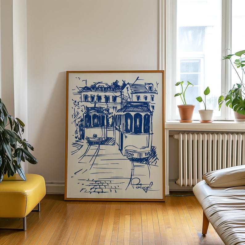 May include: A framed blue ink drawing of two vintage trams in front of a building with the word "Portugal" written at the bottom.