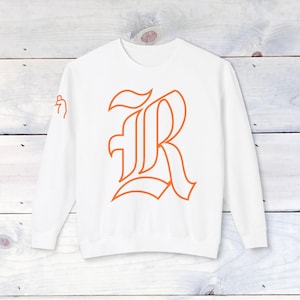 May include: White sweatshirt with a large orange outline of the letter "R" in a gothic font.