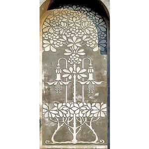 May include: A white, stylised floral design carved into a grey stone archway. The design features a tree with flowers and leaves, and a decorative border around the archway.