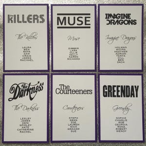 Op de afbeelding: Zes witte kaarten met paarse randen tonen bandnamen zoals "The Killers", "Muse" en "Imagine Dragons". Elke kaart toont de bandnaam in vette tekst, samen met een lijst met namen eronder. De achtergrond is zilverkleurig en glinsterend.