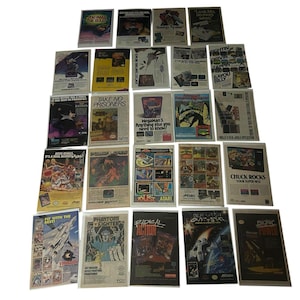 May include: A collection of twenty-five vintage video game advertisements arranged in a grid. Each rectangular print features colorful graphic illustrations, bold typography, and promotional text for various classic titles, showcasing diverse artistic styles from the era.