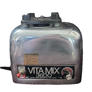May include: A vintage Vita Mix 3600 blender with a stainless steel finish. The blender features a toggle switch for blade direction and a dial for speed control. The text "Vita Mix 3600" is prominently displayed.