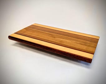 Autentyczna drewniana deska do krojenia: naturalne usłojenie, antypoślizgowe silikonowe nóżki. Wykonana z najwyższej jakości drewna, ręcznie wykończona dla zapewnienia trwałej jakości.