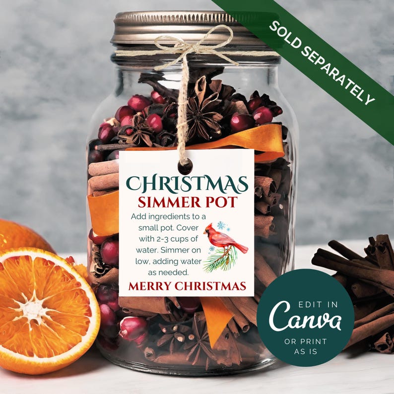 Puede incluir: Un tarro de vidrio lleno de palitos de canela, an&iacute;s estrellado, ar&aacute;ndanos y c&aacute;scara de naranja. Una etiqueta blanca con el texto "Christmas Simmer Pot" e instrucciones de uso est&aacute; unida al tarro. La etiqueta tambi&eacute;n incluye una ilustraci&oacute;n de un cardenal rojo y el texto "Merry Christmas".