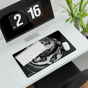 May include: A black and white abstract design mousepad with a white keyboard and mouse. The mousepad has a liquid-like pattern. A computer monitor displays the time as 2:16 PM. The text "TIGERI.STUDIO" is visible on the mousepad.
