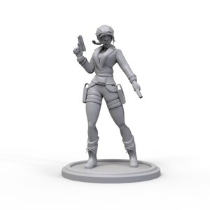 以下が含まれることがあります： ジャケットとズボンを着た女性のグレーのフィギュアで、片手に銃、もう片手にホルスターを持っています。彼女は丸い台座の上に立っています。