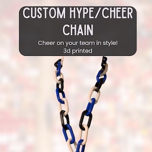 May include: A 3D-printed chain necklace with alternating black, white, and blue links. The necklace has a blue pendant with a white letter "W". The image includes text that reads "CUSTOM HYPE/CHEER CHAIN" and "Cheer on your team in style!"