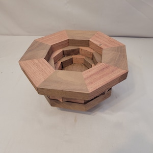 May include: A wooden octagonal bowl with multiple layers, each layer is a different shade of brown.