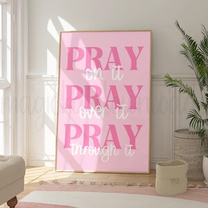 May include: Pink and white inspirational quote poster with the text "Pray on it Pray over it Pray through it".