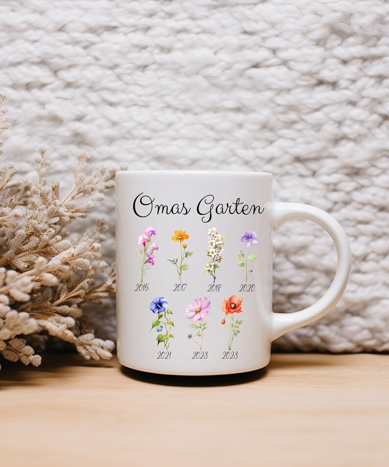May include: White ceramic mug with the text "Omas Garten" and a floral design. The flowers are arranged in rows with the years 2015, 2017, 2018, 2020, 2021, 2023, and 2023 printed below them.