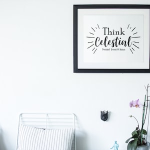 May include: A black framed print with the text "Think Celestial" and the name "President Russell M. Nelson" in a white room with a white metal bed frame and a potted orchid plant.