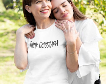 May include: Two people, a mother and daughter, are hugging each other. The mother is wearing a white t-shirt with the text "Think Celestial" printed on it. The daughter is wearing a white shirt with a ruffled sleeve. They are both smiling and looking at the camera.