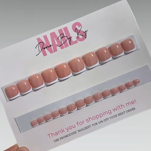May include: A set of press-on toenails in a light pink hue with white tips, displayed on a white card. The card has the text "NAILS Done By Ky" and "Thank you for shopping with me!" printed on it.