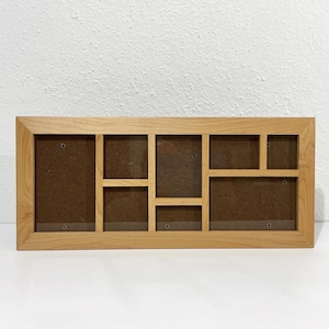 May include: A rectangular light-toned wooden collage picture frame featuring six distinct openings of varying sizes. The frame has a smooth finish and includes brown backing boards visible within each of the six individual display sections.