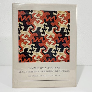 May include: A hardcover book titled Symmetry Aspects of M. C. Escher's Periodic Drawings by Caroline H. MacGillavry. The cover features a repeating tessellation pattern of lizards in black, white, and red on a light beige background.